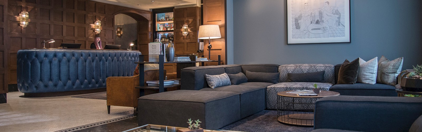 Elegant living room with sofas, coffee table, books, and wall art.