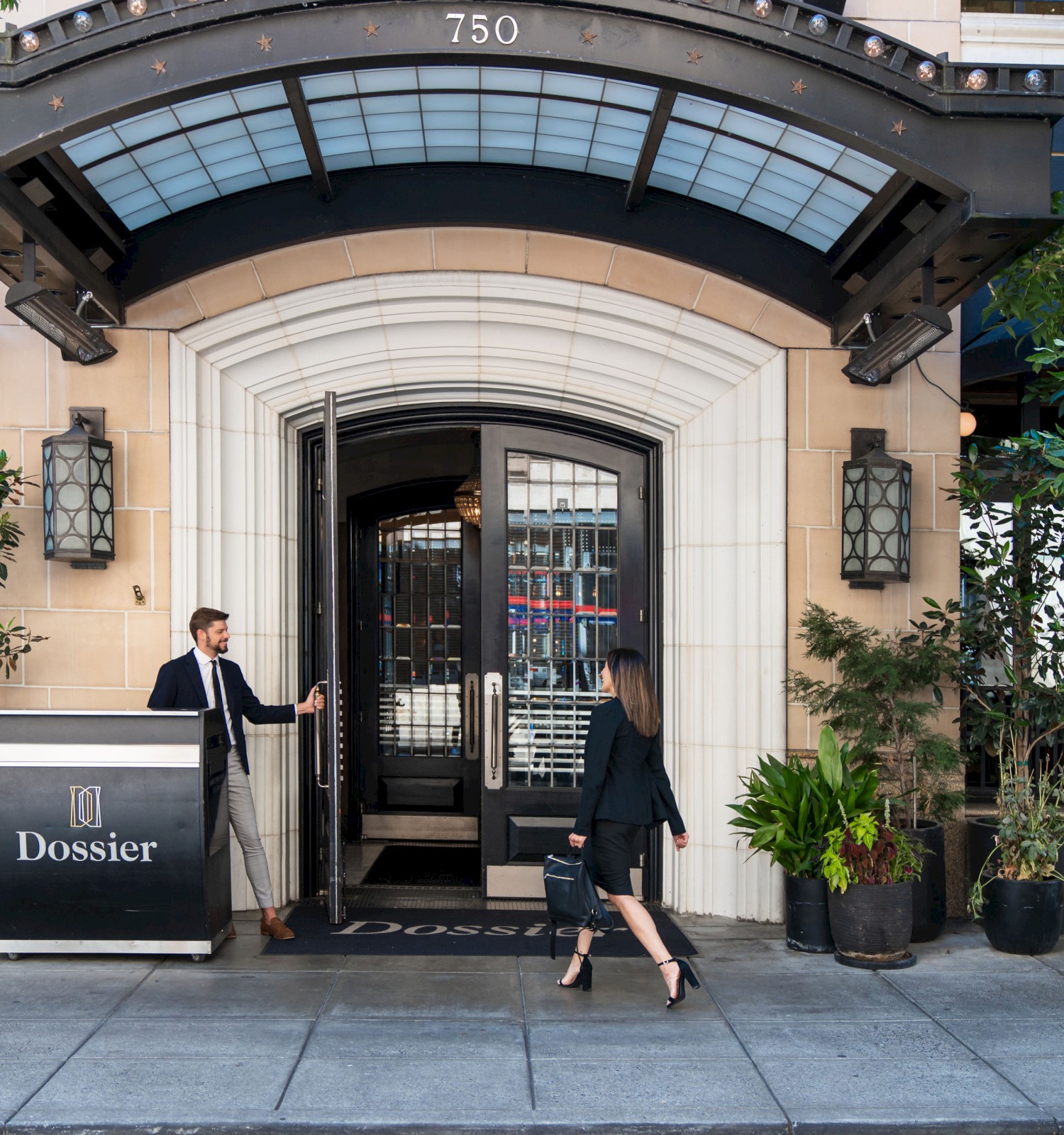 A man opens the door for a woman entering a building labeled 