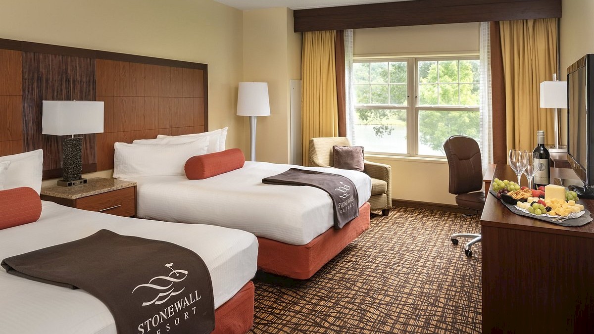 A hotel room with two beds, a window, a TV, and a food tray.
